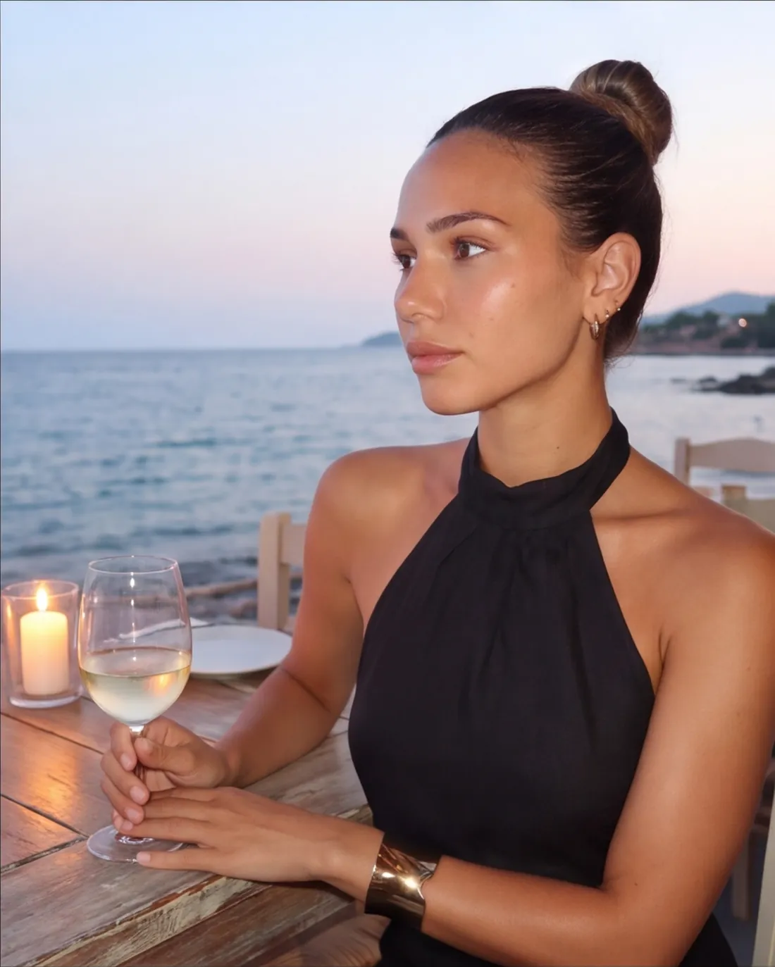Ines za stolom kraj mora u sumrak, sveće